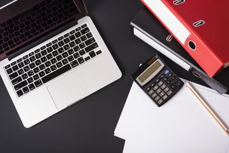 overhead-view-laptop-file-folders-calculator-pencils-paper-black-artifin-accountants